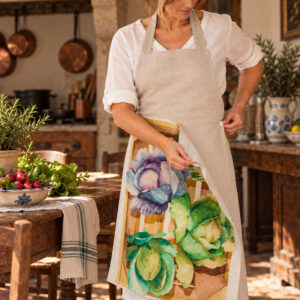 Natural linen apron with interchangeable botanical linen tea towel being buttoned onto the front