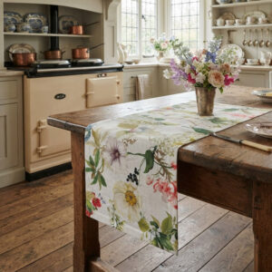 One-of-a-kind Ibisco floral linen table runner, hand-cut in Italy, draping over a farmhouse kitchen table, La Bottega di Casa
