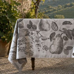 Fruit jacquard linen tablecloth in black on an outdoor table with Veneto hills in the background — pears, branches and blossoms in dark grey botanical engraving on pale ground