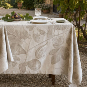 Fruit jacquard tablecloth in natural on a garden table with grapevine and fresh figs — figs and leaves in tone-on-tone natural beige