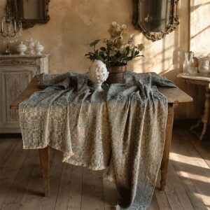Optical linen tablecloth in green, on rustic wooden table with white hellebore, natural light