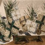 tablecloth with design with festive elements such as wrapped gift boxes with green and beige ribbons, pine branches, pinecones, and delicate ornaments