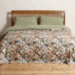 cotton bedspread with a sophisticated, nature-inspired design featuring lush foliage and delicate flowers