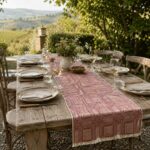 Burgundy Intersezioni hemp and Egyptian cotton table runner on an outdoor dining table.