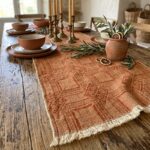 Terracotta Intersezioni hemp and cotton table runner styled with pottery and olive branches.