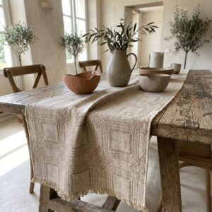Natural Intersezioni hemp and Egyptian cotton runner on an antique wood table in a bright interior.