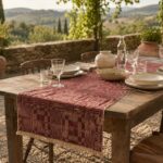 Burgundy Optical jacquard table runner with fringe on an outdoor country dining table