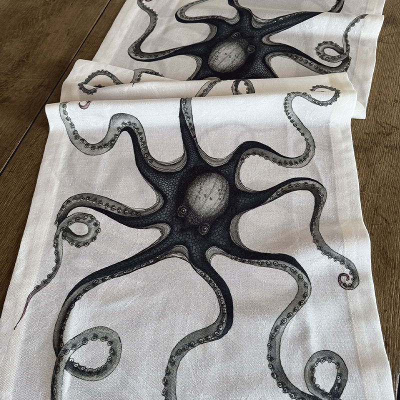 Polipo octopus linen-cotton table runner-La-Bottega-di-Casa Close-up of the Polipo linen-cotton jacquard table runner with black and gray octopus artwork on an ivory ground