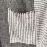 Striped linen pocket against charcoal herringbone panel on One-of-a-Kind No. 2 apron