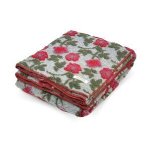 Folded Amy Gray boiled wool throw with raised red flowers and olive-green leaves on light gray, finished with red edge stitching.
